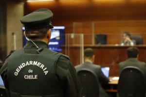 Fotografía de gendarme dando la espalda en un estrado.