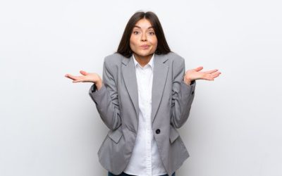 Young business woman over isolated white background having doubts while raising hands