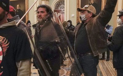 FILE - Rioters, including Dominic Pezzola, center with police shield, are confronted by U.S. Capitol Police officers outside the Senate Chamber inside the Capitol, Wednesday, Jan. 6, 2021, in Washington. A Proud Boy far-right extremist group member whose smashing out of a window at the U.S. Capitol on Jan. 6, 2021, allowed some of the first rioters to enter the building testified Wednesday, April 19, 2023, that he acted alone. Pezzola is one of five Proud Boys facing seditious conspiracy and other charges in one of the most high-profile trials to emerge from the insurrection. (AP Photo/Manuel Balce Ceneta, File)