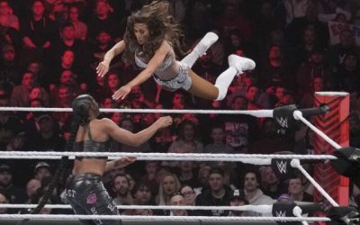 File - Wrestler Carmella leaps at Bianca Belair, during the WWE Monday Night RAW event, March 6, 2023, in Boston. WWE's weekly television show "Raw" will move to Netflix next year as part of a major streaming deal. (AP Photo/Charles Krupa, File)
