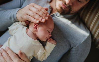 Close-up of father cuddling his little new born baby.